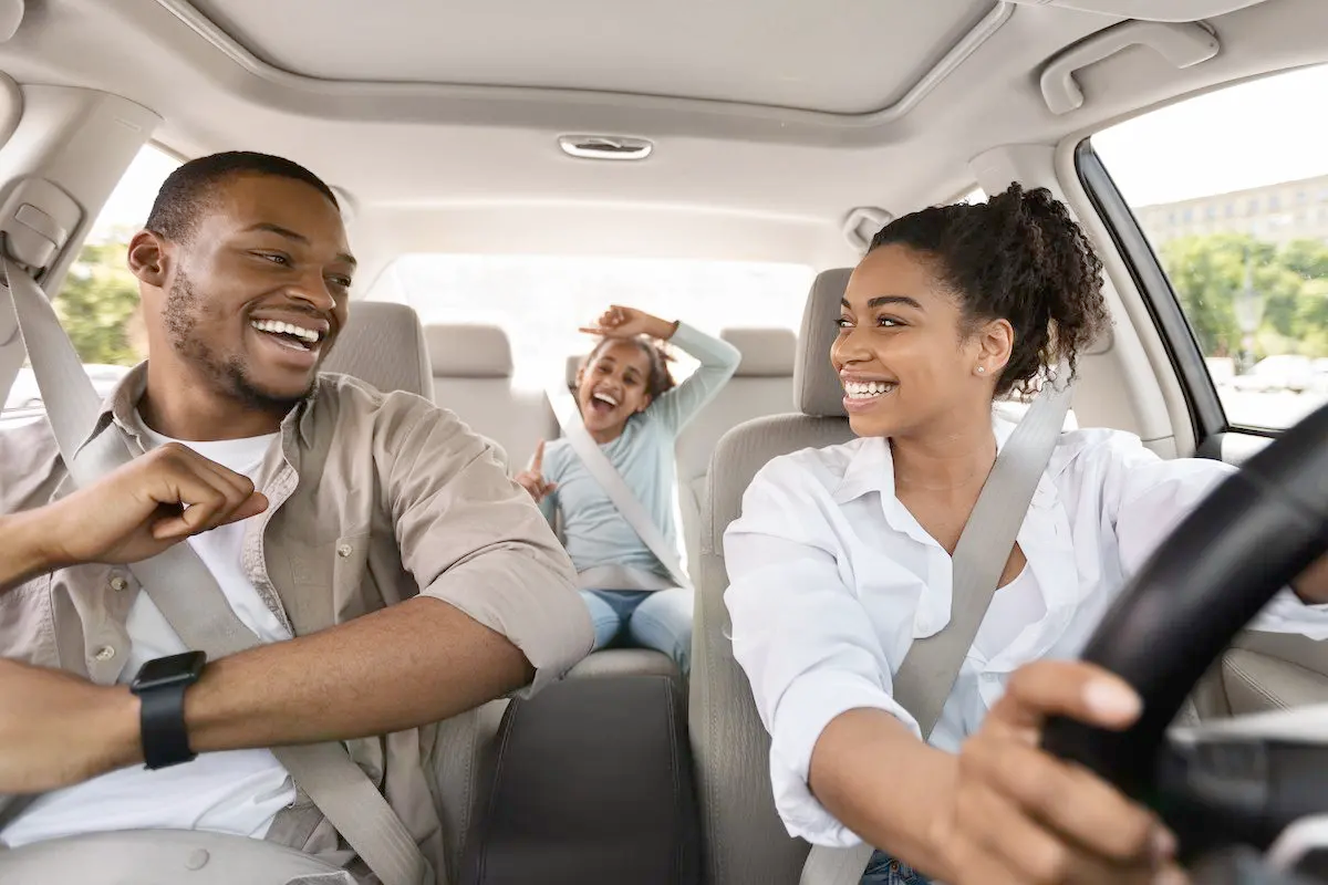 Happy car owner reviewing competitive insurance quotes on a tablet